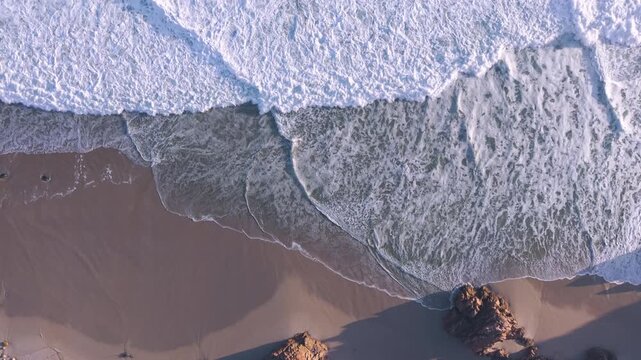 Aerial overhead waves breaking on the coastline