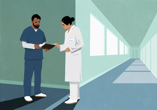 Doctor and nurse discussing medical chart in hospital corridor