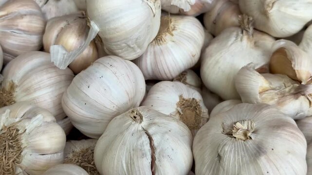 Full frame close up view of a large pile of fresh raw garlic bulbs in a market.