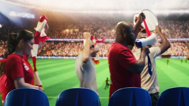 Football supporters in red jerseys blow vuvuzelas and create lively stadium atmosphere for fan culture, stadium atmosphere and team support content.