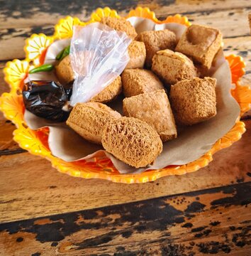 Traditional Indonesian fried tofu snack served on floral plate with chili peppers and condiments.
