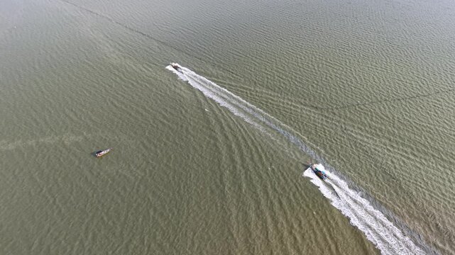 Aerial drone shot of fishing boats moving at Kuala Gula