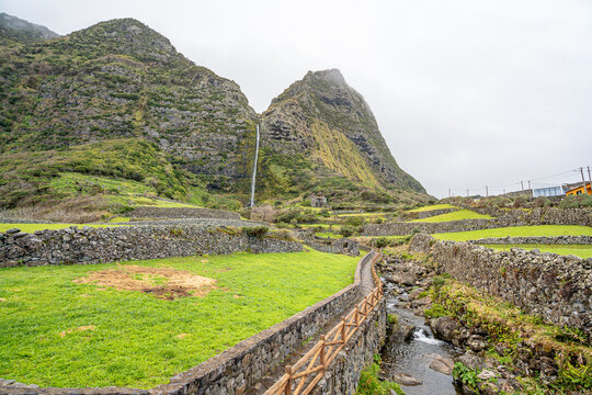 Codfish Well Waterfall with surrounding green area, Ilha das Flores. Ribeira do Ferreiro bridge, Flores Island, Azores, Portugal.