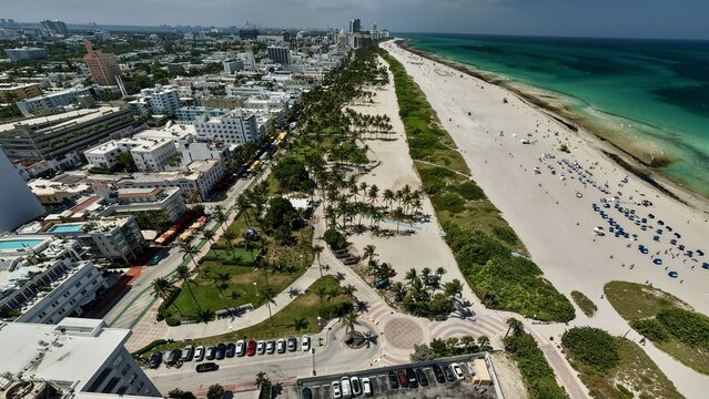 Aerial view of South Beach featuring the sandy coastline, turquoise Atlantic Ocean waters, lush palm trees, and Art Deco architecture in Miami Beach, Florida, United States.
