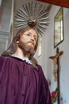 Detailed sculpture of Jesus Christ wearing a purple robe and a metallic halo.