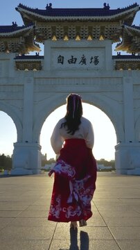 Vertical video, 4k Slow motion video, Chiang Kai Shek Memorial Arch with morning sunlight and Asian women in Taipei, Taiwan.