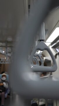 Close-up of hand straps inside a Japanese commuter train, symbolizing daily urban transportation, public transit, rush hour commuting, and modern city life in Japan.