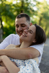 Fototapeta premium Young couple embracing outdoors with genuine smiles and affection