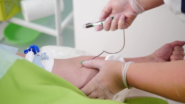 Healthcare professional collecting a blood sample from a patient's arm using a vacuum blood collection tube during a clinical procedure.