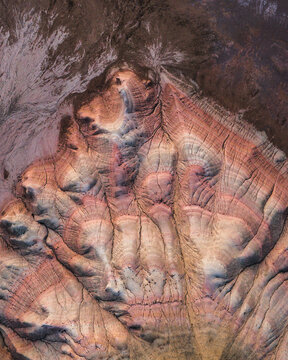 Aerial view of the colorful Karynzharyk desert landscape with intricate geological formations and layered sedimentary rock patterns in Karakiya District, Mangystau Region, Kazakhstan.