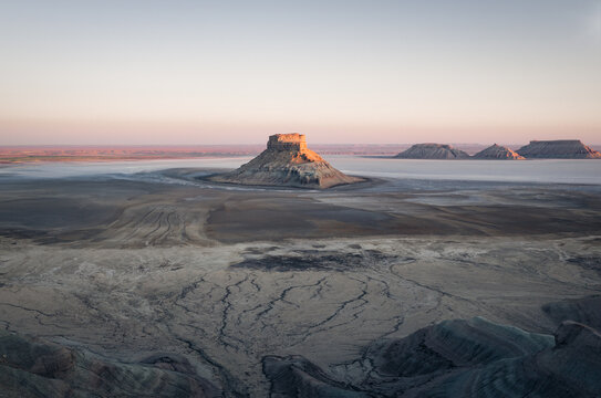 Aerial view of Karynzharyk depression featuring dramatic desert mesas and salt flats in the arid landscape of Karakiya District, Mangystau Region, Kazakhstan.