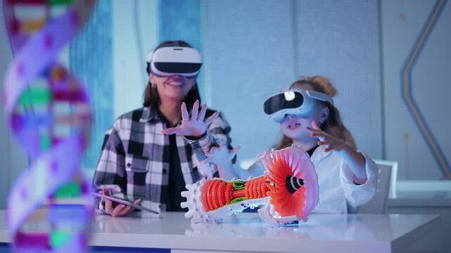 Technology in education of school, teacher woman and girl interacting with virtual reality headsets at tech lab table reaching for holographic model and exchanging high five while panning right.