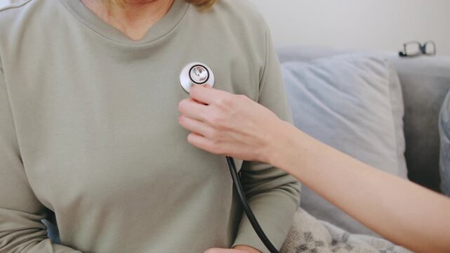 Healthcare professional performing a chest examination with a stethoscope during a routine medical checkup.