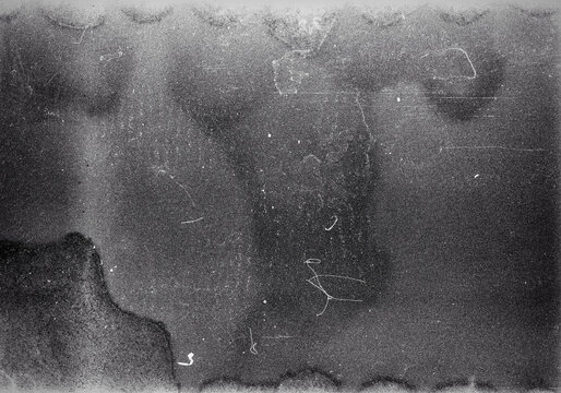 Blank grained film strip texture background with heavy grain, dust and light leak. Old expired soviet moldy photographic film scan. Black and white.