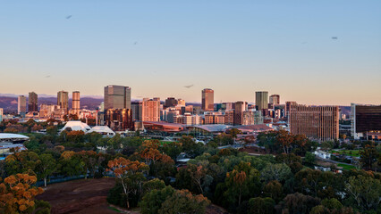 Obraz premium Adelaide City, South Australia – 4K aerial drone footage of CBD skyline, Towers, River Torrens, Convention Centre, Elder Park, city bridges and golden sunset cityscape.