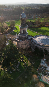 Close Aerial View of St Chad's Church Dome and Golden Cross and graveyard Over Shrewsbury Skyline, United Kingdom, England