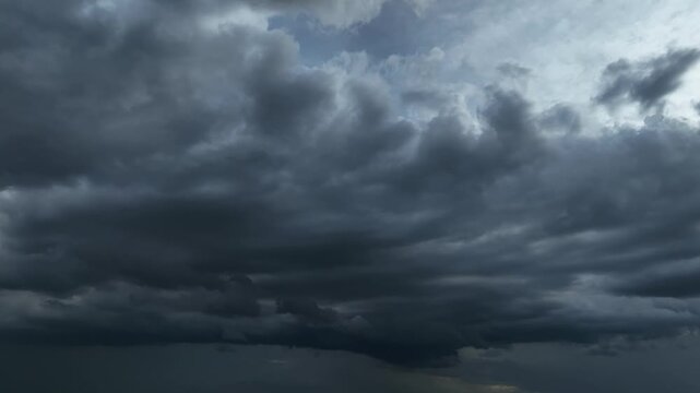 High-altitude aerial view of towering dark clouds before heavy rain, illustrating atmospheric instability, natural weather transformation, and the intensity of seasonal storm development. 4k.
