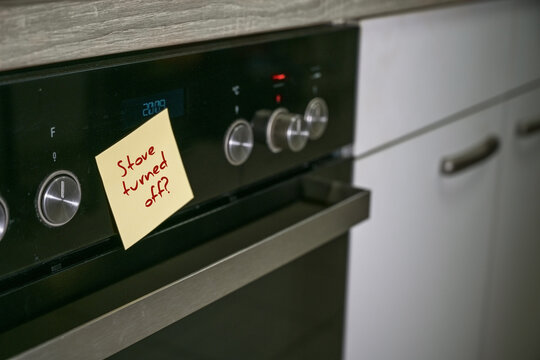 Stove in an old kitchen with a sticky note and reminder text, Stove turned off. Safety concept for dementia or aging forgetfulness in everyday life, copy space