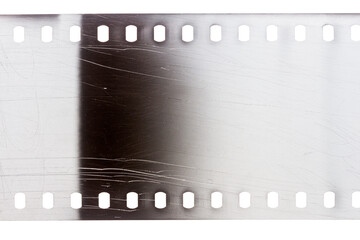 Dusty and grungy 35mm film texture or surface. Perforated scratched camera film isolated on white background. © Taigi