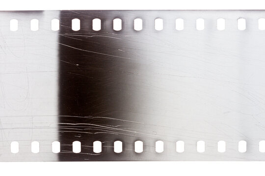 Dusty and grungy 35mm film texture or surface. Perforated scratched camera film isolated on white background.