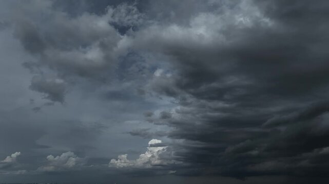 Aerial drone view of massive dark storm clouds gathering across the sky, symbolizing extreme weather, approaching rainfall, and the powerful forces of nature shaping the atmosphere. 4k.
