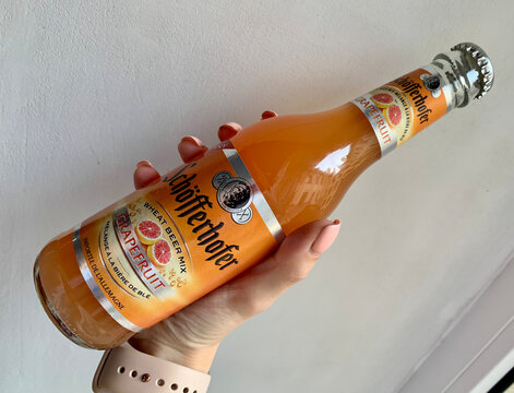 Saint Petersburg, Russia &ndash; July 2, 2019 &ndash; Sch&ouml;fferhofer Grapefruit wheat beer mix in a glass bottle held in a woman&rsquo;s hand