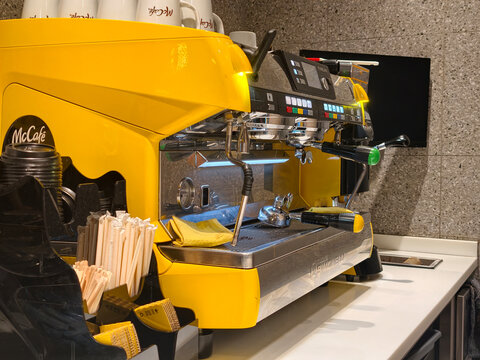 Turkey, Istanbul, June 26, 2026. Yellow coffee machine at a McDonald's cafe counter preparing drinks.