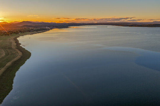 Aerial scene overlooking Lake Keepit and the surrounding rural landscape at sunset, with warm golden light reflecting across the tranquil reservoir in NSW, Australia.