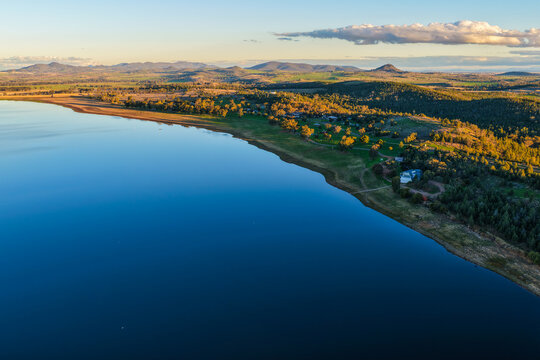 Aerial scene showcasing Lake Keepit, the sailing club and shoreline campground, surrounded by the expansive rural landscape and tranquil waters of the reservoir in NSW, Australia.