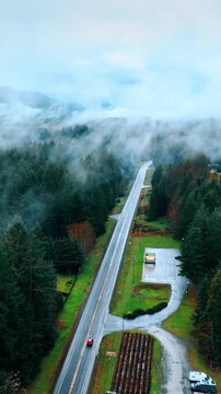 Thick haze covering the scenery of Mount Rainer national Park, Washington State, the USA. Drone footage above the beautiful nature landscape crossed by the highway with one car on. Vertical video