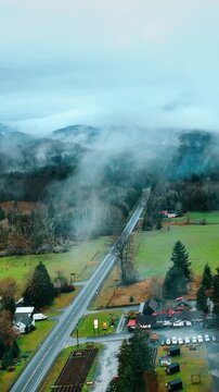 Cottages and parking lots in the valley of Mount Rainer national Park, Washington State, the USA. Top view on the misty forests covering the gorgeous mountains. Vertical video