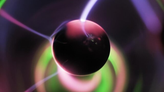 Macro pan down a plasma ball electrode showing its inner coil structure surrounded by bright purple and pink ionized gas. Electric filaments and wavy streamers flow inside the glass.