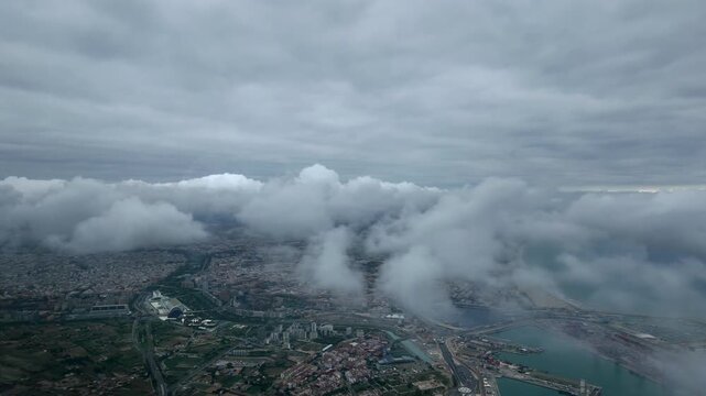 Aertial cockpit view taken from an airplane cockpit of Valencia City (VLC) Covered by Broken Clouds in a Stormy Morning
