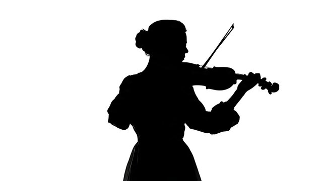 Silhouette of person playing violin outdoors at dusk.