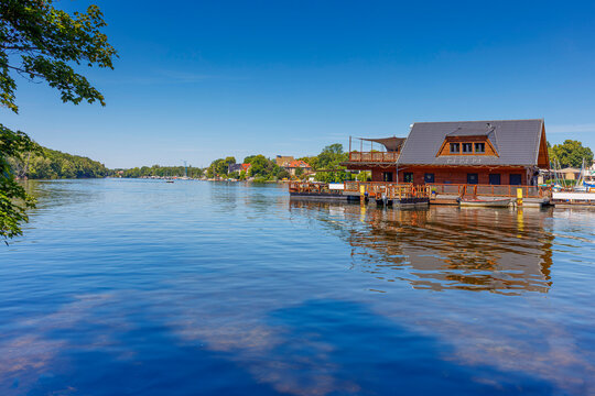 Berlin Friedrichshagen im Hochsommer - Blick auf die M&uuml;ggelspree mit Ruderclubs, Marina und Anlegestellen, unweit M&uuml;ggelsee. Gesunder Natur im Berliner Umland - Wassersport Berlintipps