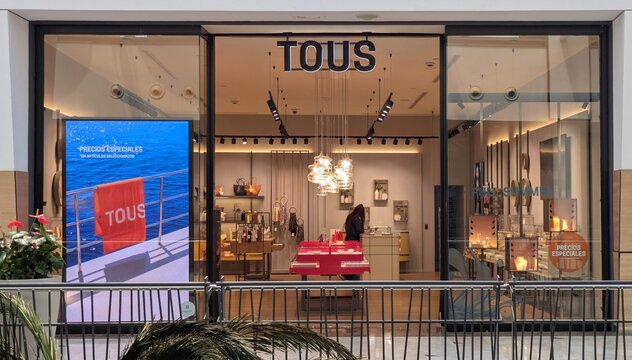 Entrada con escaparates con carteles de Precios especiales de joyer&iacute;a Tous en centro comercial Islazul en Madrid, Espa&ntilde;a, 26 de junio de 2026
