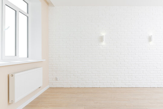 Empty room interior in light pastel colors with white decorative brick wall, wooden texture laminate floor and window sill