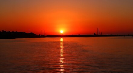 Fototapeta premium Vibrant Crimson Sunset Over Calm Ocean Water with Scenic Golden Horizon