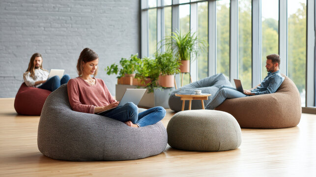 Young gen z people working on laptop in bright workplace with aesthetic bean bag chairs and natural light creating calm vibe