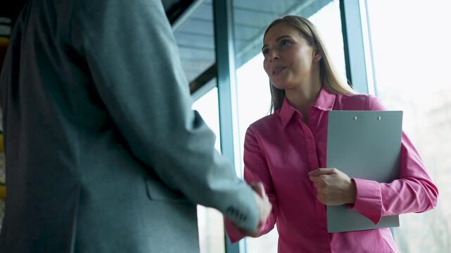 Handshake, greeting and meeting for people in office, welcome or business partners in bank for loan. Finance, startup and women with man for negotiation, lender and assessment of application or funds