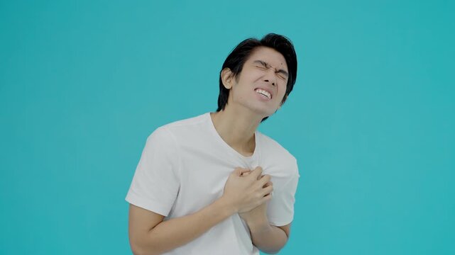 hand hold chest with heart attack symptoms, asian man have chest pain caused by heart disease, leak, dilatation, enlarged coronary heart, press on the chest with a painful expression