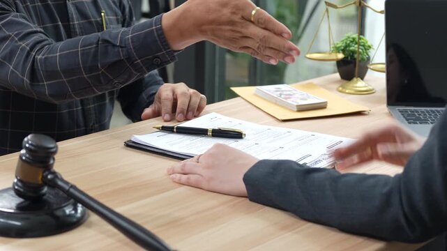 Close-up of a cash payment being handed over during a legal or business meeting, symbolizing financial transactions, settlement, agreement, bribery, corruption, or contract-related payment.