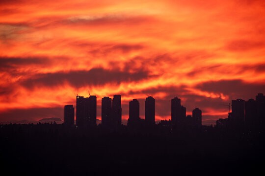 Dramatic Red Sunset Silhouette of Modern City Skyline