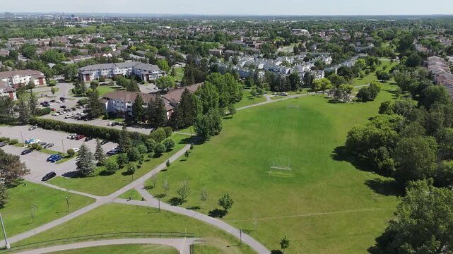 Drone footage of a residential neighbourhood located near a park with a soccer field