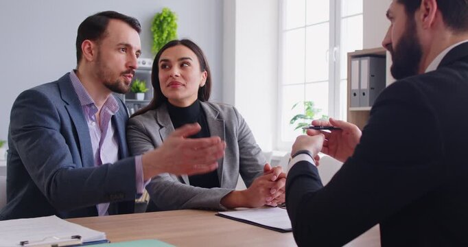 Office people, couple speaking, engaged in conversation or meeting with agent, making serious important decision or consultation in professional environment, focused pair listening, contract at desk