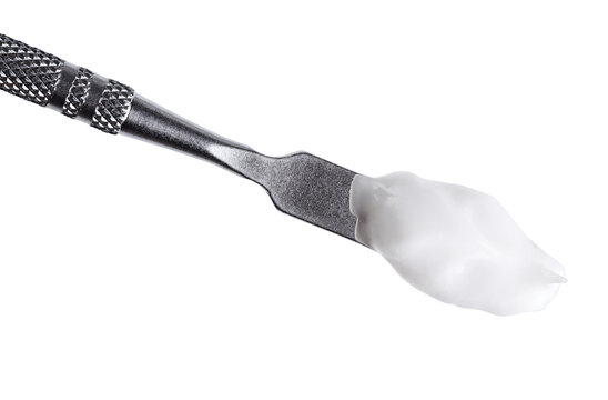 Cosmetic spatula with moisturizing cream isolated on white background.