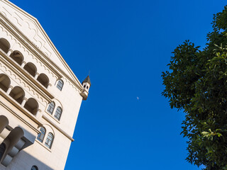 Tilted view of white castle building corner and small turret against blue sky © syu