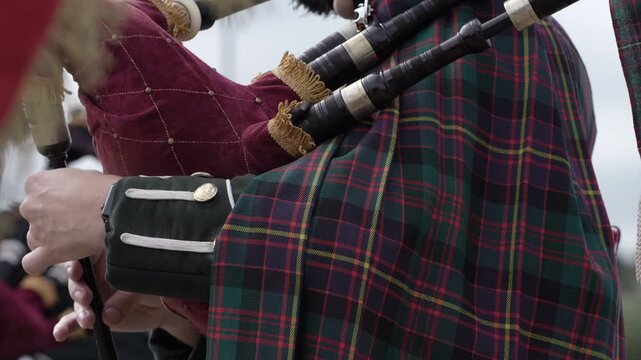 Scottish piper playing Bagpipes wearing Tartan playing traditional folk music