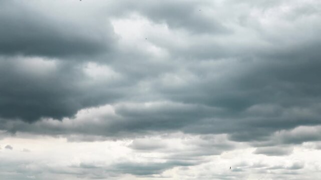 Timelapse 4k storm dramatic clouds are floating across the sky. Stormy sky with dark, snowy clouds on a spring day. Clouds are floating across the sky. Dark blue clouds swiftly floating across sky. 
