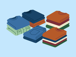 Neatly folded piles of colorful clothes on a blue background © muty